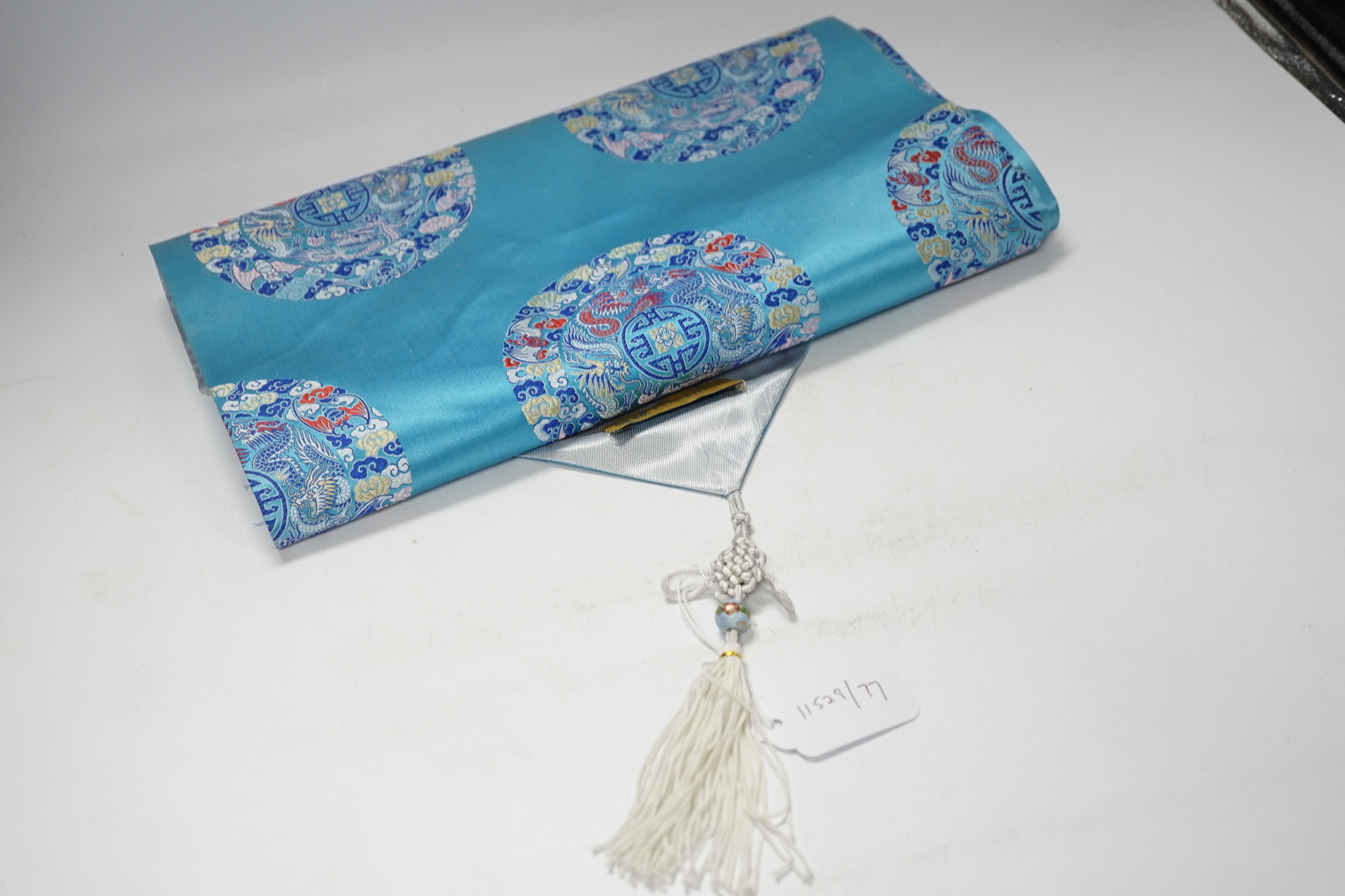 A 20th century Chinese hanging scroll watercolour on silk, two cranes on a pine tree, with brocade border, together with a blue Chinese silk table runner with brocade mon decoration